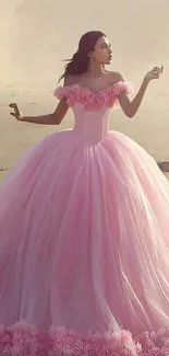 Woman in elegant pink ball gown on a tranquil beach.