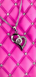 Pink quilted background with heart necklace.