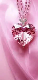 Pink heart pendant on silky pink background wallpaper.