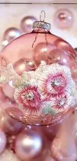 A delicate pink ornament with floral embroidery design.