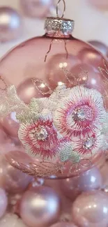 Elegant pink ornament with floral embroidery in a festive setting.