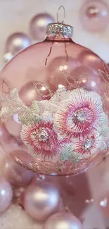 Elegant pink ornament with floral embroidery on a glass bauble.