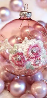 Elegant pink ornament with floral embroidery on a festive background.