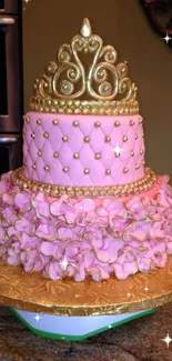 Pink princess cake with gold crown decorations on top.