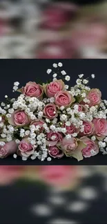 A bouquet of pink roses with white flowers on a dark gray background.