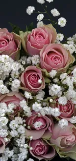 A bouquet of pink roses and baby's breath against a dark background.
