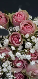 Bouquet of pink roses with white flowers on a mobile wallpaper.