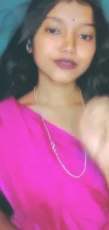 Woman in pink sari with elegant expression.