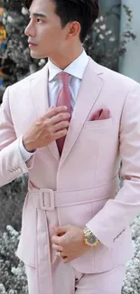 Man in an elegant pink suit, exuding style.