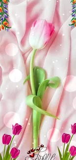 Pink tulip on soft pink fabric background with decorative accents.