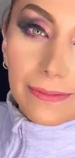 Close-up of face with vibrant makeup and pink tones.