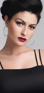 Elegant portrait of a woman with black dress and hoop earrings.