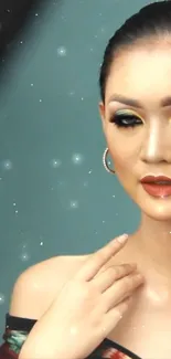 Elegant portrait of a woman with vibrant makeup against a sparkly teal backdrop.