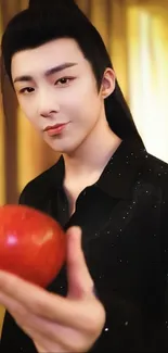 Person holding a red apple with a warm, softly lit background.