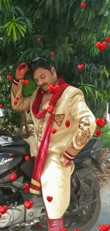 Man posing elegantly on motorcycle with red hearts and greenery.