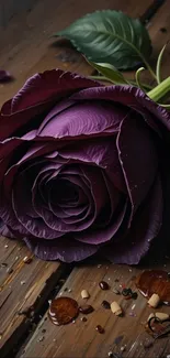Purple rose on rustic wooden background with scattered petals.