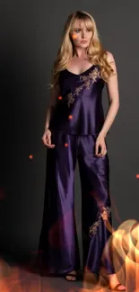 Woman in elegant purple satin attire against dark background.