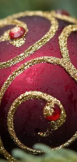 Close-up of a red ornament with gold glitter swirls.