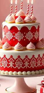 Red and white decorated cake with candles.