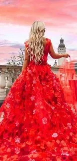 Woman in a red dress on a rooftop at sunset.