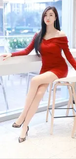 Woman in an elegant red dress sitting gracefully.