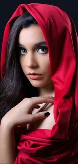 Woman in red hood against dark background wallpaper.