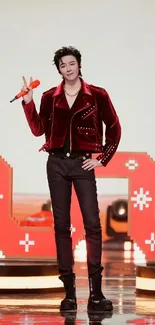 Person in a red jacket posing on stage.