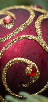 Close-up of red ornament with golden swirls and gemstones.