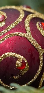 Red holiday ornament with gold glitter swirls on a festive background.