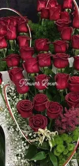 Elegant arrangement of red roses with green foliage in a heart shape.