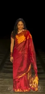 Woman in red saree on railway track, dramatic scene.