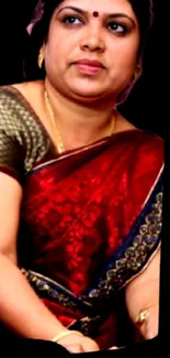 Woman wearing a red saree on dark background.