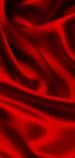 Luxurious red silk fabric wallpaper with elegant folds.