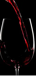 Elegant red wine splashing into a glass with a dark background.