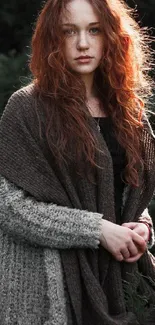 Red-haired woman in shawl, serene portrait with green backdrop.