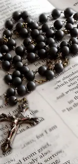 Rosary beads elegantly placed on an open book page, creating a serene visual.