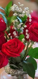 Vibrant bouquet of red roses with green leaves in a clear vase.