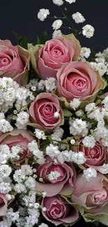 Beautiful bouquet of pink roses with baby's breath against a dark background.