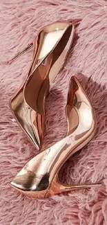 Rose gold high heels on a soft pink fluffy background.