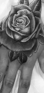 Black and white rose tattoo on hand close-up.