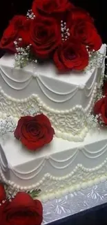 Two-tier white wedding cake with red roses.