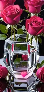 Vibrant pink roses in a crystal vase on a reflective surface.