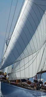 Sailing yacht with white sails on blue ocean.