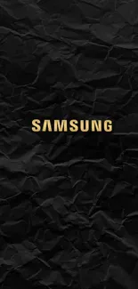 Crumpled black background with golden Samsung logo.