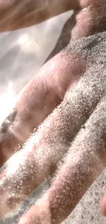 A hand covered in sand with light reflections.