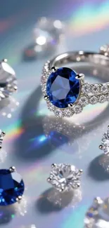 Elegant sapphire ring and diamonds on a reflective surface.