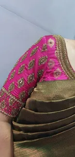 Close-up of a pink and green saree with intricate patterns.