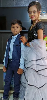 Elegant portrait of siblings in stylish attire indoors.