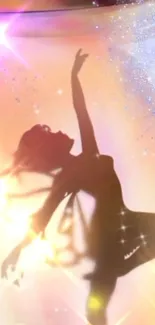 Silhouette of a dancer against a sparkling, golden background.