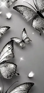 Metallic silver butterflies on a gray background, creating an elegant pattern.